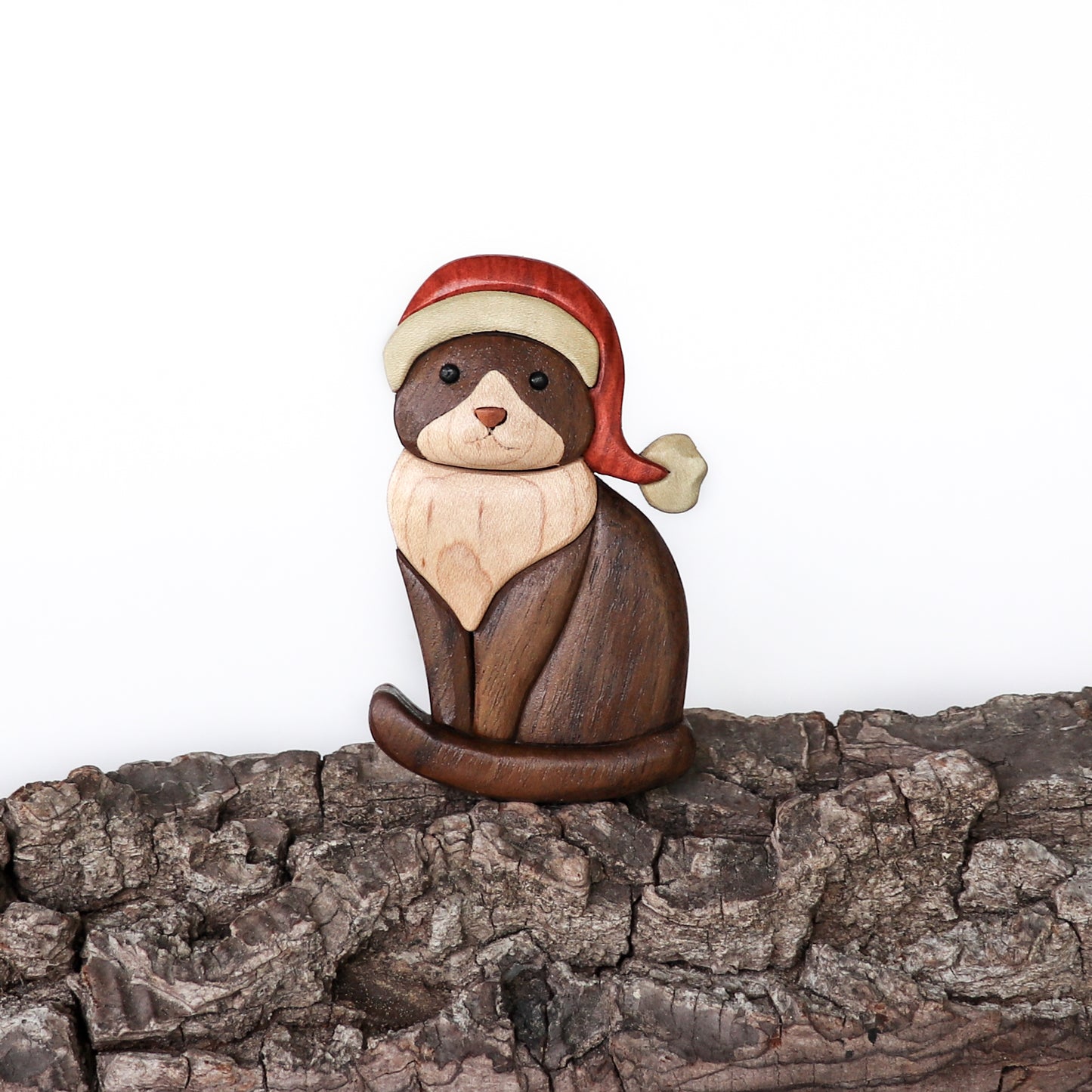 Wood carving ornament of a tuxedo cat using Peruvian walnut, maple, holly, red cedar, and holly.